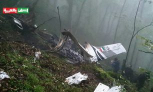 بالفيديو والصور: حطام طائرة رئيسي ونقل جثمان أحد الضحايا image